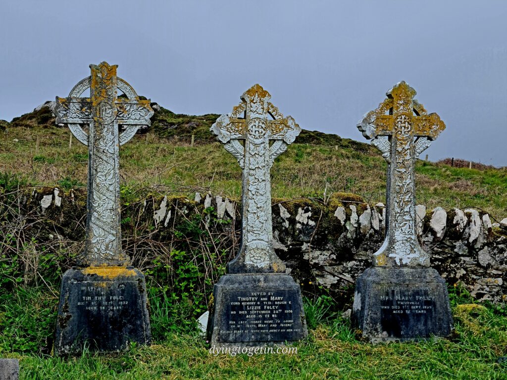 Three celtic cross headstons back onto a stone wall. The first partial inscription reads In loving memory of Timothy Foley Died >> September 1932 Aged 78 years. The second reads: Erected by Timothy and Mary fond memory of their daughter Lizzie Foley who died September 22nd 1908 aged 15 years. Her last words were I'm going to my Jesus, Mary, and Joseph. Sacred heart of Jesus have mercy on her soul. The third one reads: In loving memory of Mrs Mary Foley Waterville who died 7th Sept 1930 *(or 1939) aged 72 years