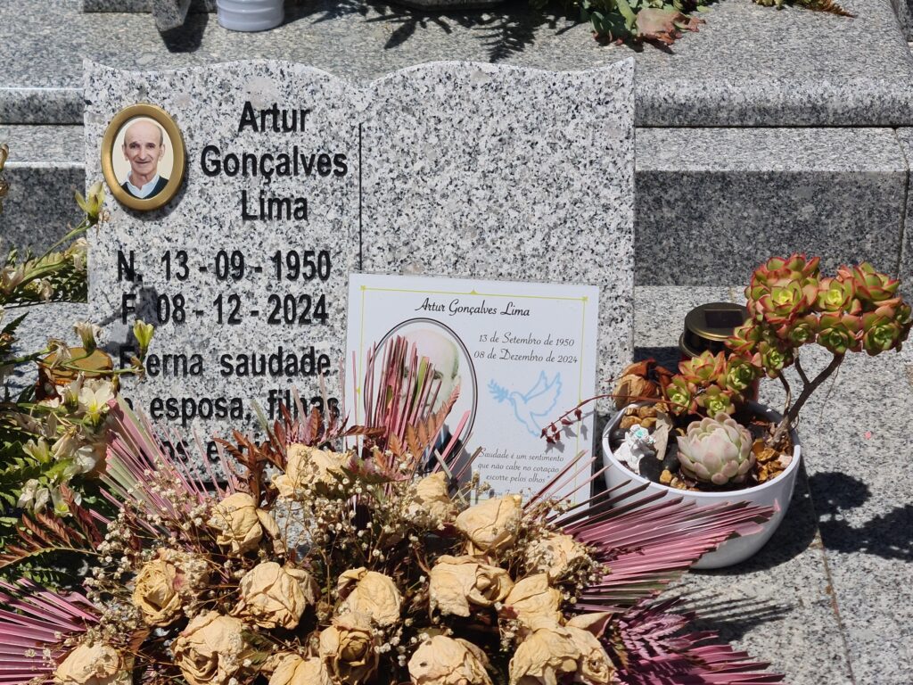 headstone of Artur Goncalves Lima - born 13-9-1950 died 8-12-2024,,, a dried flower bouquet sits on the grave with a small bonsai tree beside it